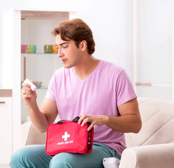 Sick man at home with first aid kit — Stock Photo, Image