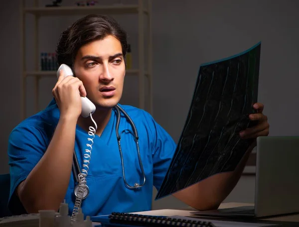 Young handsome doctor working night shift in hospital