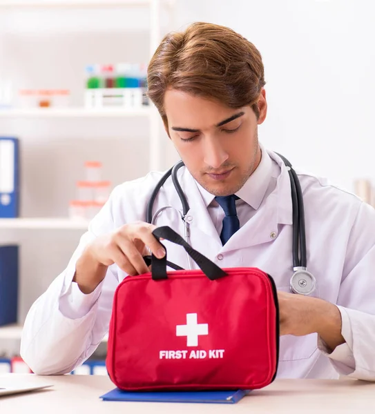 Jovem médico com kit de primeiros socorros no hospital — Fotografia de Stock