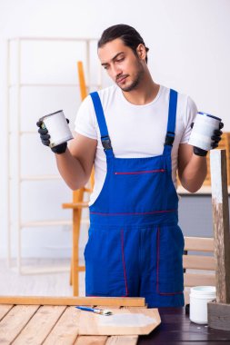 Genç erkek müteahhit atölyede çalışıyor.