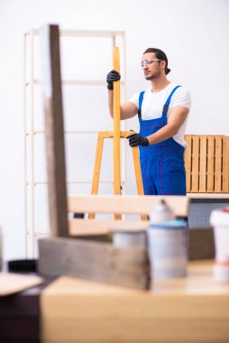 Genç erkek müteahhit atölyede çalışıyor.