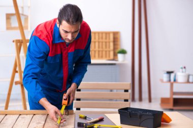 Genç erkek müteahhit atölyede çalışıyor.