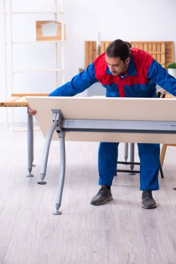 Genç erkek müteahhit atölyede çalışıyor.