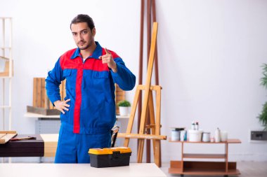 Genç erkek müteahhit atölyede çalışıyor.