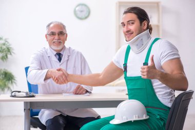 Genç erkek müteahhit yaşlı doktoru ziyaret ediyor.