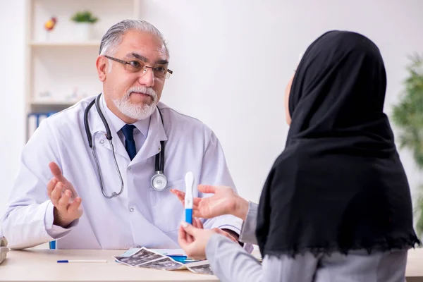 Mujer árabe que visita médico experimentado — Foto de Stock