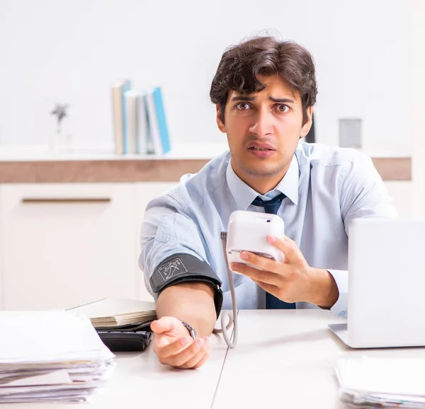 Man under stress measuring his blood pressure — Stock Photo, Image