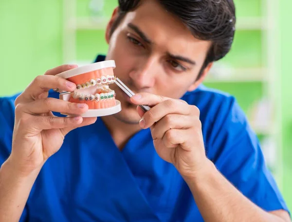 Erkek dişçi yeni diş implantı üzerinde çalışıyor. — Stok fotoğraf