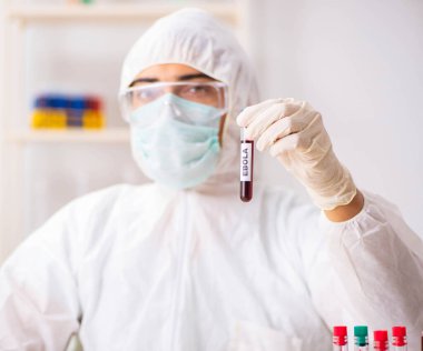 Genç yakışıklı laboratuvar asistanı hastanede kan örnekleri test ediyor.