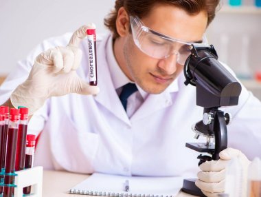 Genç yakışıklı laboratuvar asistanı hastanede kan örnekleri test ediyor.