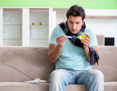 Evde hastalıktan muzdarip genç yakışıklı bir adam.