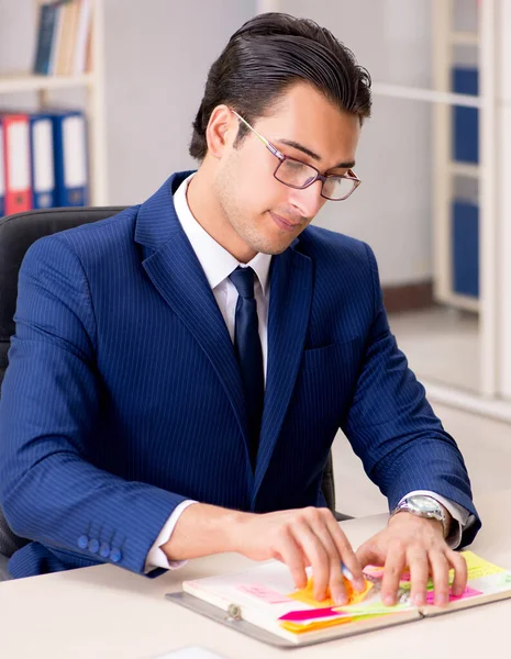 Joven empleado guapo planeando su actividad laboral —  Fotos de Stock