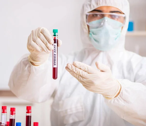 Asistente de laboratorio joven guapo analizando muestras de sangre en el hospital —  Fotos de Stock