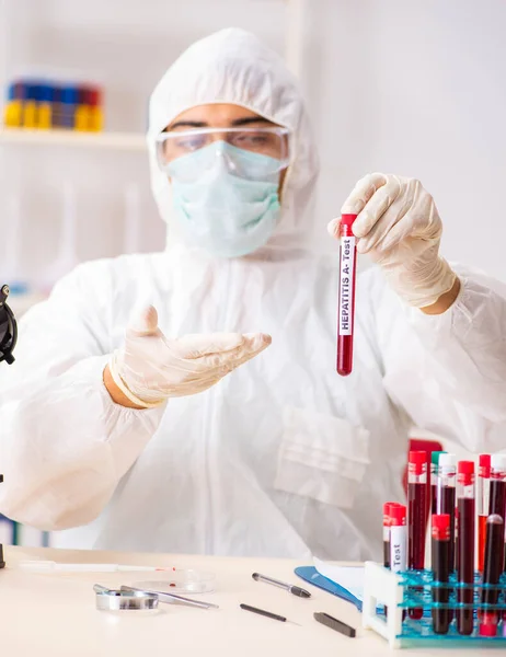 Asistente de laboratorio joven guapo analizando muestras de sangre en el hospital — Foto de Stock