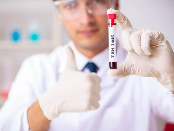 Asistente de laboratorio joven guapo analizando muestras de sangre en el hospital — Foto de Stock