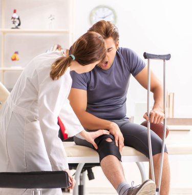 Genç erkek hasta, kadın doktor travmatoloğu ziyaret ediyor.