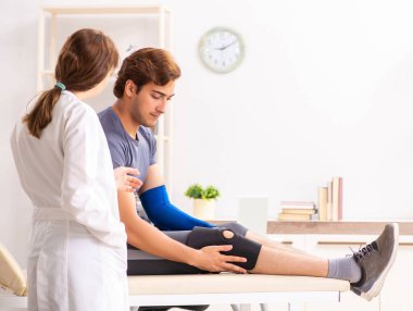 Genç erkek hasta, kadın doktor travmatoloğu ziyaret ediyor.