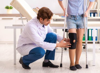 Genç bayan hasta erkek doktor travmatoloğu ziyaret ediyor.