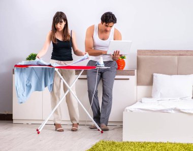 Genç kadın kocası için ütü yapıyor.