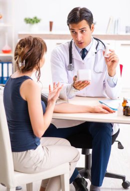 Genç doktor, kadınların tansiyonunu ölçüyor.