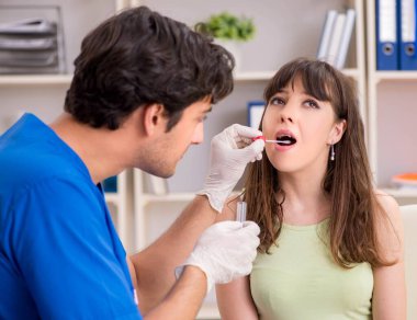 Tartar çıkarmak için erkek doktor dişçisini ziyaret eden genç bir kadın