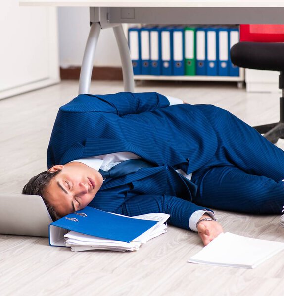 Tired exhausted businessman working overtime in office