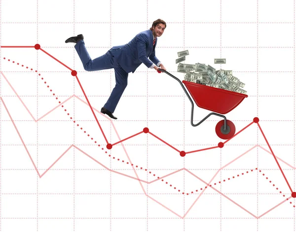 Üzletember nyomja pénz talicska lefelé a diagramon — Stock Fotó