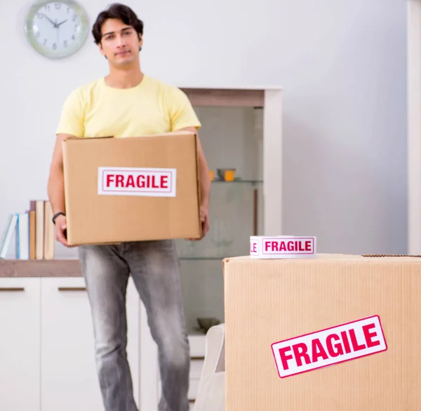 Hombre mudanza casa y reubicación con elementos frágiles —  Fotos de Stock