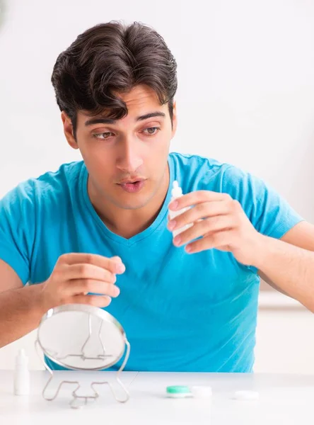 Homem tentando lentes de contato em casa — Fotografia de Stock