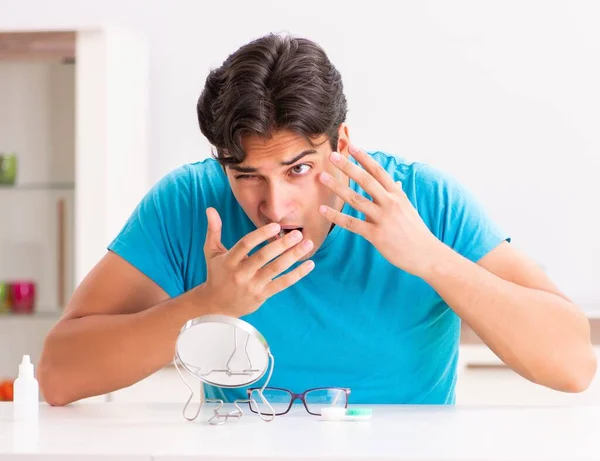 Hombre tratando de lentes de contacto en casa —  Fotos de Stock