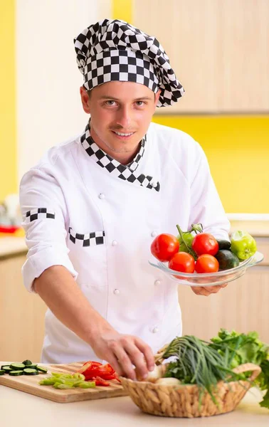 Jovem cozinheiro profissional preparando salada na cozinha — Fotografia de Stock