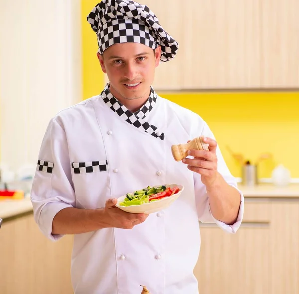 Jonge professionele kok bereidt salade in de keuken — Stockfoto