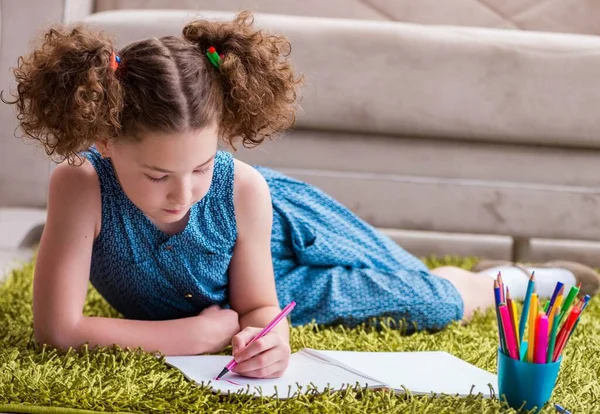 Маленькая девочка рисует на бумаге карандашами — стоковое фото