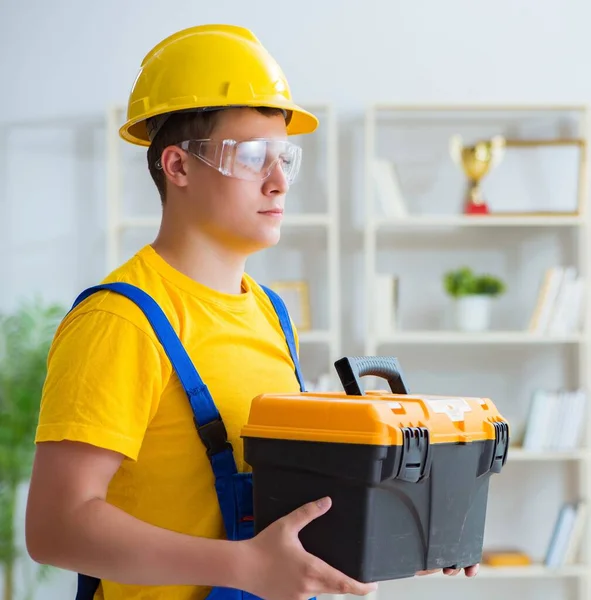 Young contractor doing repair works at office