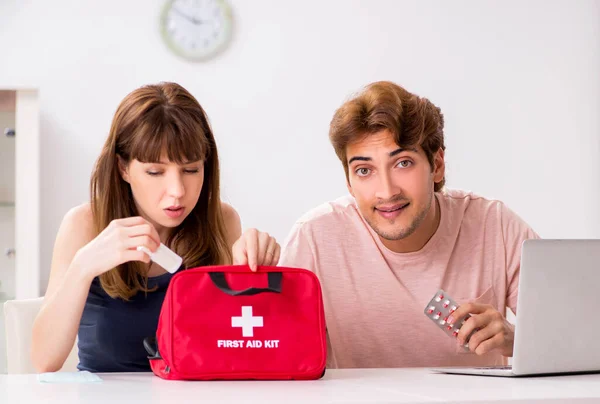 Família jovem recebendo tratamento com kit de primeiros socorros — Fotografia de Stock