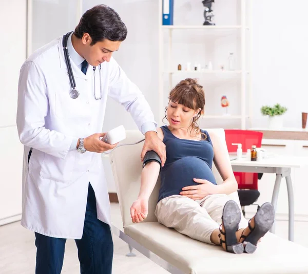妊婦の血圧をチェックする若い医師 — ストック写真