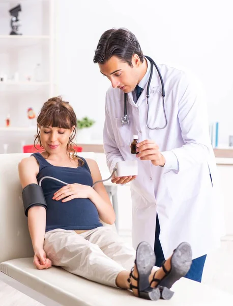 Молодой врач проверяет кровяное давление беременных женщин — стоковое фото