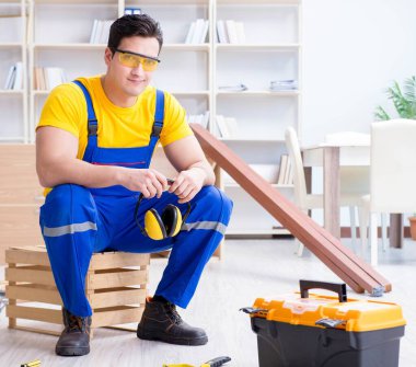 Genç müteahhit ofiste tamirat yapıyor.