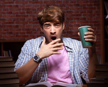 Geceleri sınava hazırlanan yakışıklı bir genç.