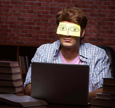 Geceleri sınava hazırlanan yakışıklı bir genç.