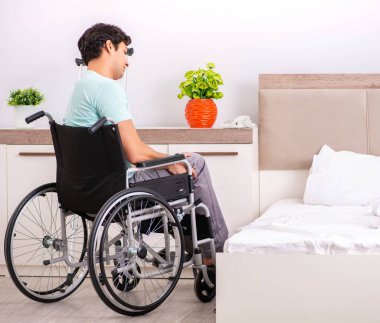 Genç yakışıklı engelli adam evde iyileşiyor.