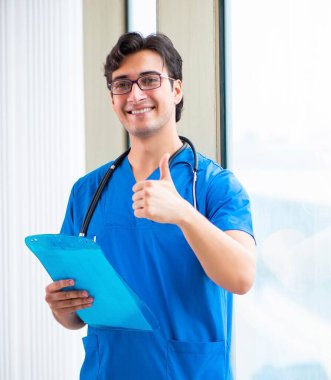 Hastanede çalışan yakışıklı genç bir doktor.