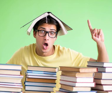 Sınavdan önce okumak için çok fazla kitabı olan öğrenci