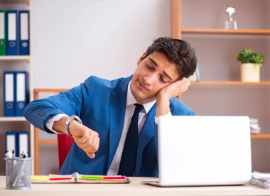 Genç yakışıklı işadamı ofiste çalışıyor.