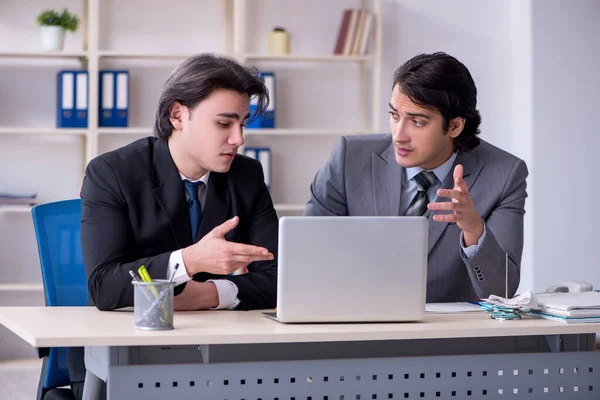 Dos jóvenes empleados que trabajan en la oficina — Foto de Stock