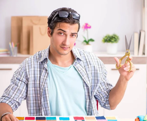 Giovane bel sarto che lavora nel suo laboratorio — Foto Stock