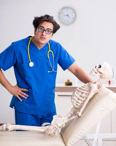 Funny doctor with skeleton in hospital — Stock Photo, Image