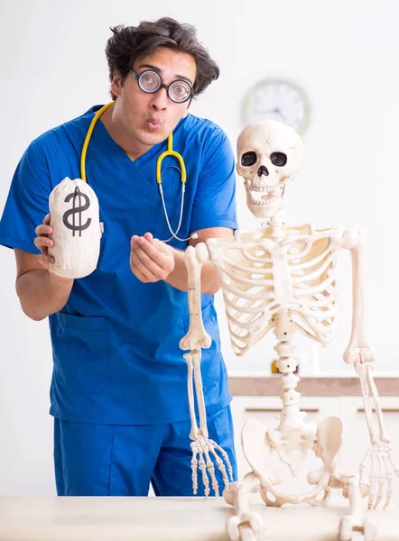 Grappige dokter met skelet in ziekenhuis — Stockfoto