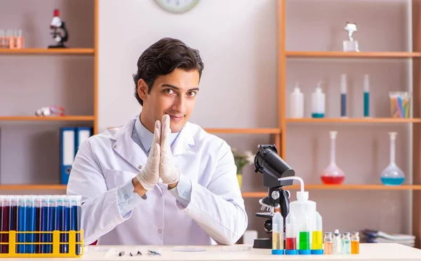 Jonge knappe biochemicus die in het lab werkt — Stockfoto