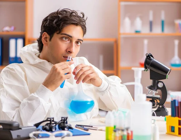 Jovem bioquímico vestindo roupa protetora trabalhando no laboratório — Fotografia de Stock